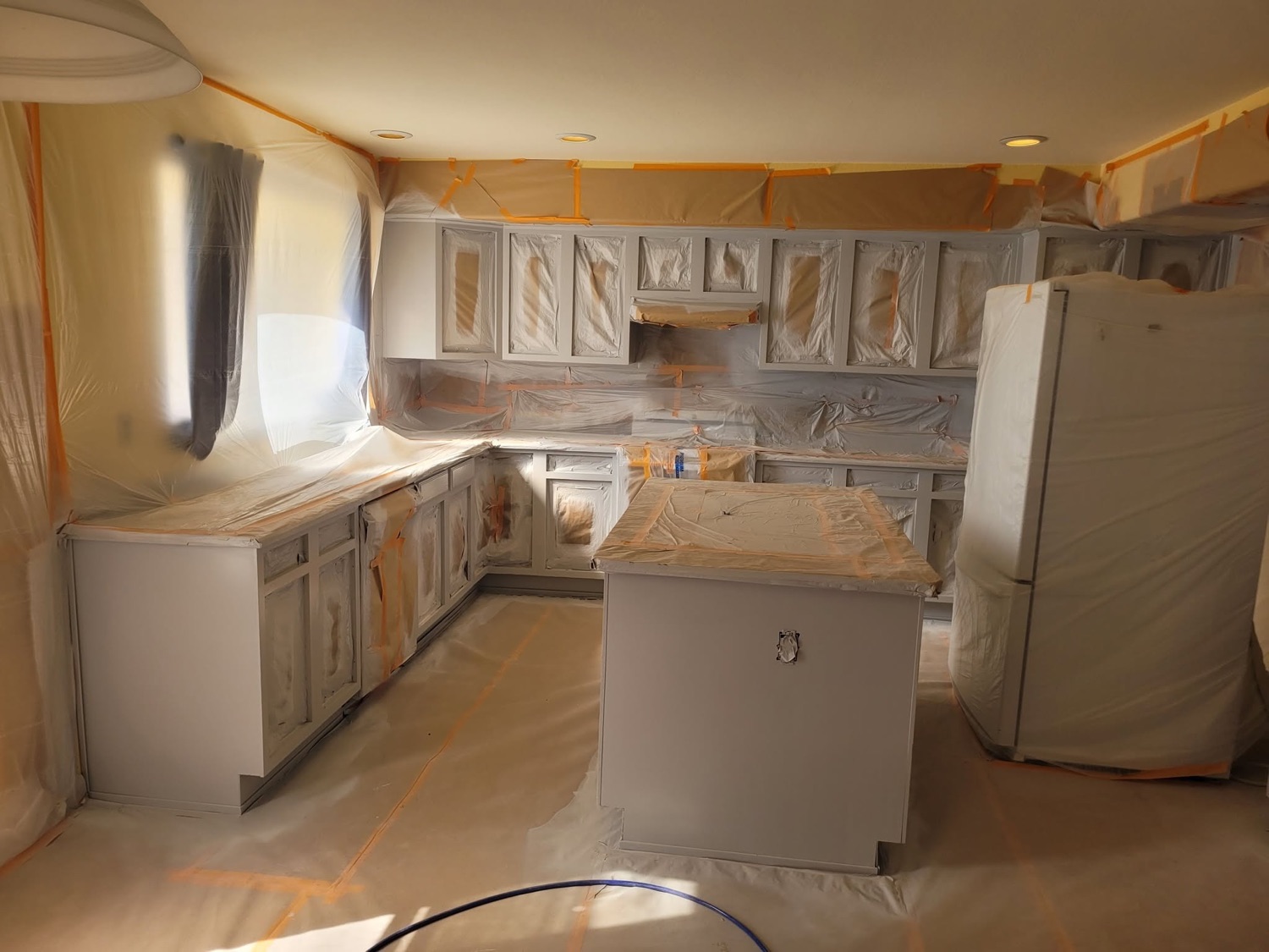 Kitchen cabinets masked and primed mid-project